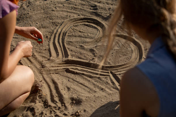 istock Creating a Heart Shape in the Soft Sand Fun and Creative Activities in Summer Time 2194726169