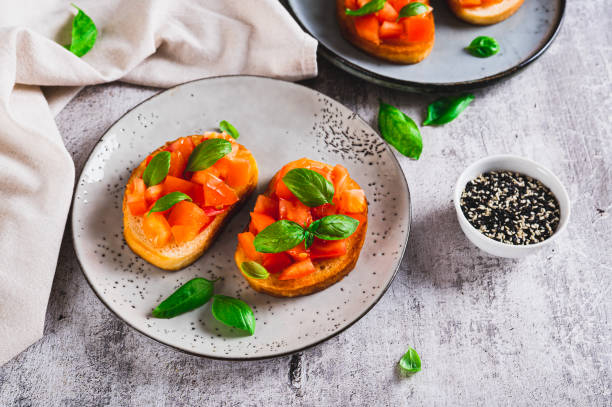 istock Italian sandwiches with tomatoes, basil and garlic on a plate on a table 2194727141