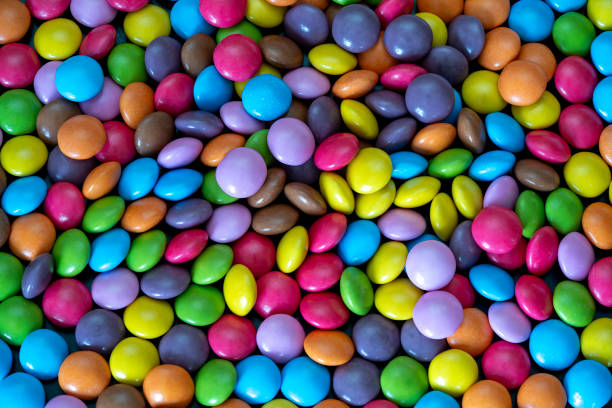 istock Colorful candy coated sweets scattered across a vibrant surface 2194727780