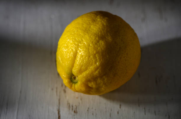 Bright yellow lemon resting on a rustic surface captures the essence of freshness in a quiet moment