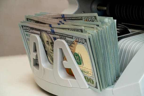 istock Money counting machine in use with one hundred dollar bills displayed 2194730402