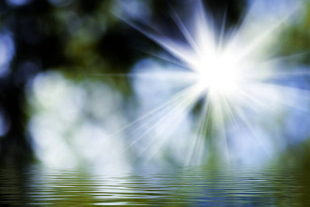 Golden rays of sunlight burst through a serene landscape, casting shimmering reflections on calm water. The enchanting scene invites a sense of peace and wonder at daybreak.