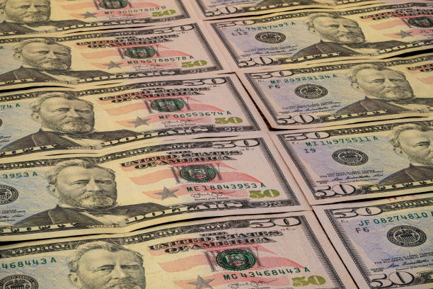 istock Collection of fifty dollar bills arranged on a flat surface 2194732865