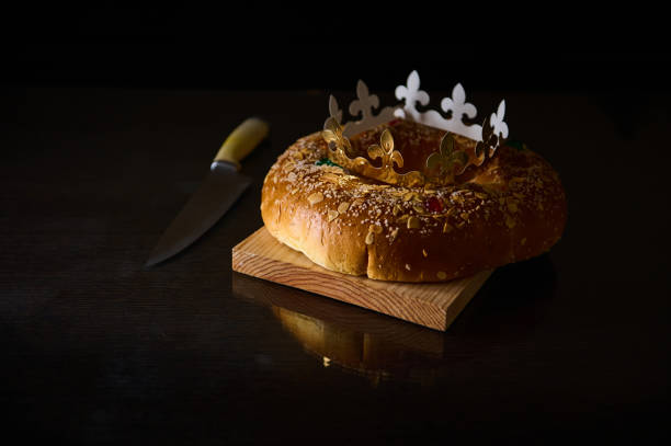 istock Traditional king cake with a golden crown on a dark reflective table 2194733193