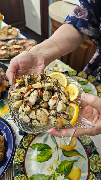 istock Female hands holding a plate with mussels and lemon 2194739862