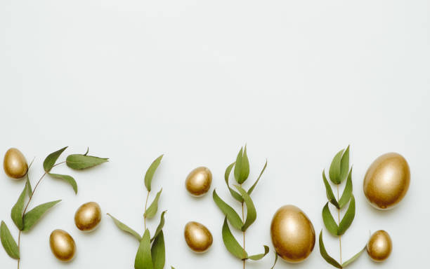 istock Close-up top view of golden Easter eggs on white background, Happy Easter minimal concept 2194740211