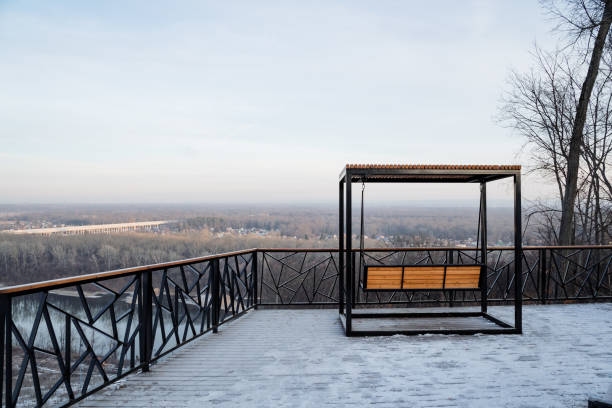 istock A charming rustic wooden bench is elegantly positioned on top of a beautiful snowcovered patio, which is situated beside a sturdy railing that enhances the breathtaking winter scene 2194740240