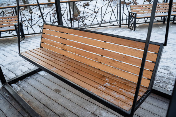 istock A beautifully crafted wooden swing is resting upon a sturdy wooden deck, which is generously blanketed in a layer of fresh, fluffy snow, creating a picturesque winter scene 2194740332