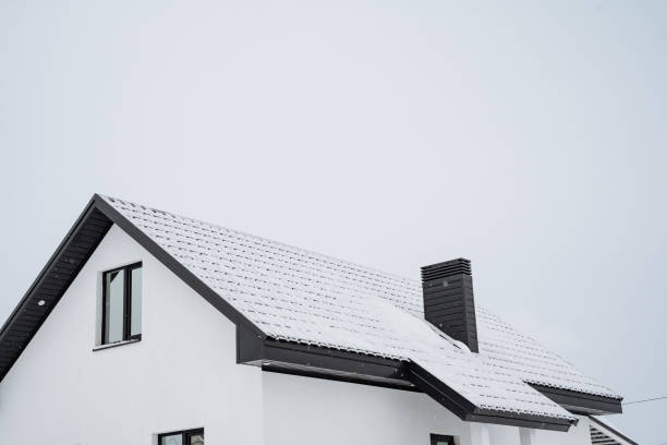 istock This inviting and cozy winter home features a charming roof blanketed in snow, under a crisp blue sky, creating a picturesque and tranquil atmosphere during wintertime 2194741753