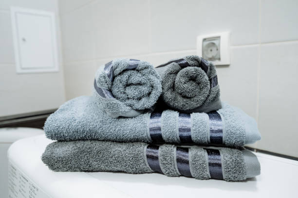 istock On a bathroom counter, a neatly arranged stack of soft towels, radiating warmth and comfort, enhances the overall ambiance of the space, making it feel inviting and cozy 2194741787
