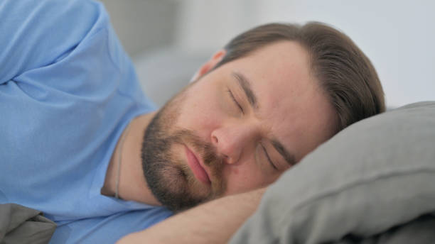 istock Face Close up of Sleeping Man Lying on Side in Bed 2194743094