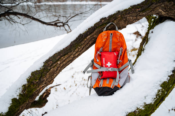 istock An orange backpack that contains a first aid kit is currently resting in the snow, positioned next to a branch of a tree, creating a stark yet intriguing scene in the winter landscape 2194743525