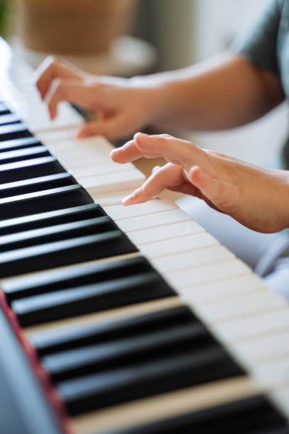 istock A talented pianist gracefully plays a beautiful melody, their hands gliding over the keys, producing enchanting music that fills the room and creates a captivating atmosphere 2194743534