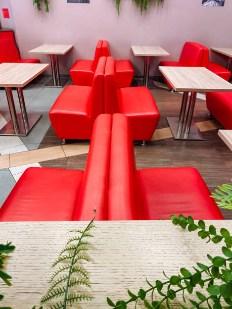 There is a vibrant restaurant that is beautifully decorated with inviting red chairs and tables, creating a warm and lively atmosphere for patrons to enjoy their meals and social events