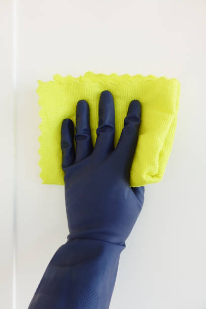istock This image shows hand cleaning being done with a yellow cloth and a blue glove on a white surface 2194743837