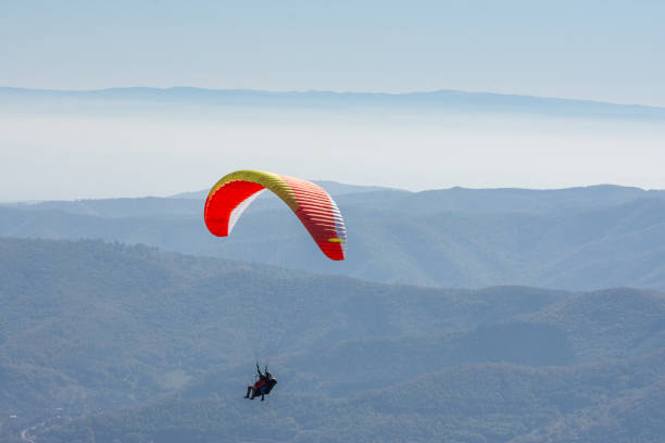 istock Flying paraglider in sky over mountains ridge 2194745481