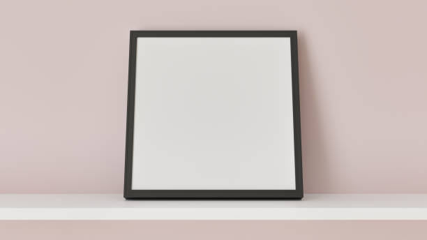 istock An empty black frame resting on a white shelf against a light pink wall 2194745838