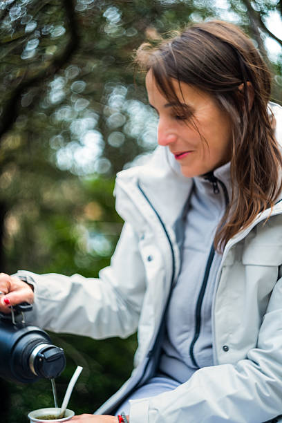 istock A woman serves herself a mate herb while resting on her hike. 2194747015