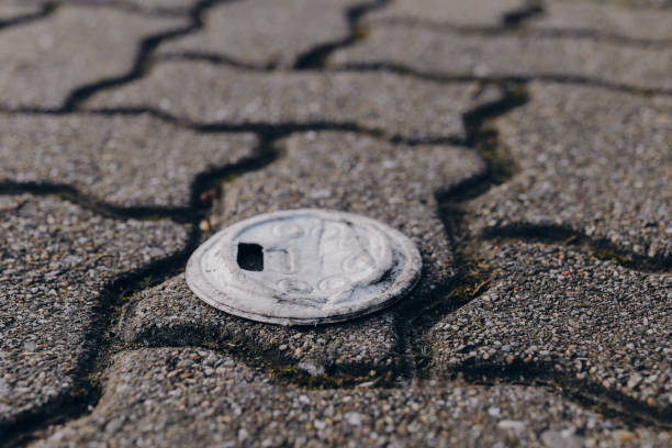 Coin resting on a textured pavement with cracked surface in an urban environment during daylight stock photo