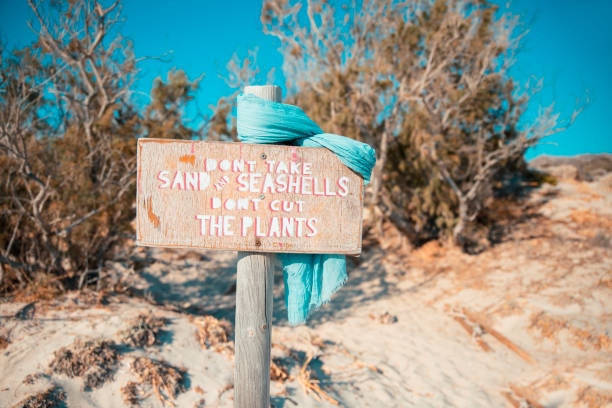 Environmental protection sign board on a sand dune at the sunny beach