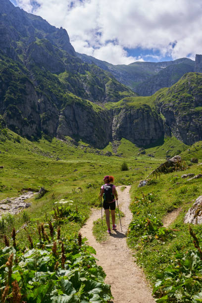 istock Hiker with backpack and poles on a trail in the mountains 2194751746