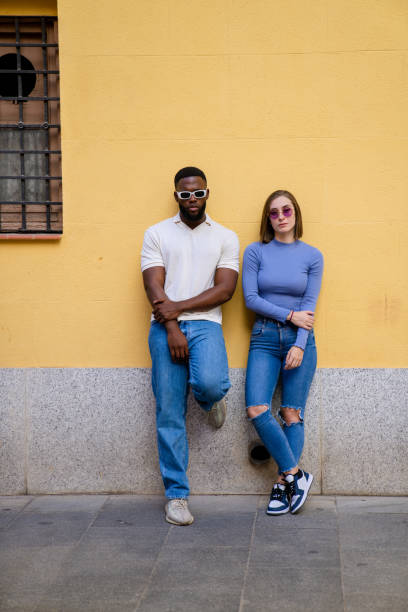 istock Multiethnic couple leaning against a yellow wall 2194757919