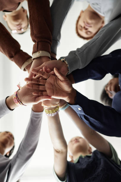 istock From Below Group of Children Stacking Hands 2194759298