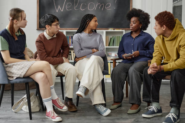 istock Diverse Group of Children with Therapist Sitting on Chairs in Circle 2194759323