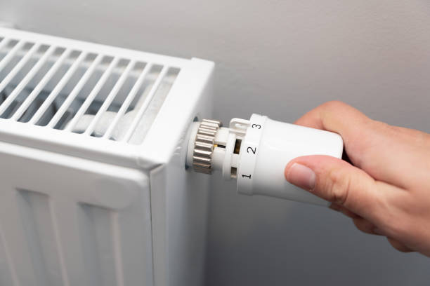 istock Person is adjusting the temperature on a radiator 2194761375