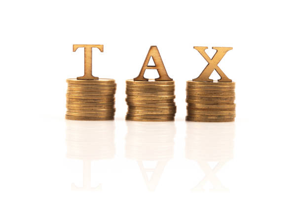 TAX word on stack of coins isolated on white background