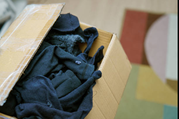 istock cardboard box filled with freshly washed and dried black socks, neatly arranged for storage or donation. Ideal for laundry, organization, and clothing-related themes 2194765648