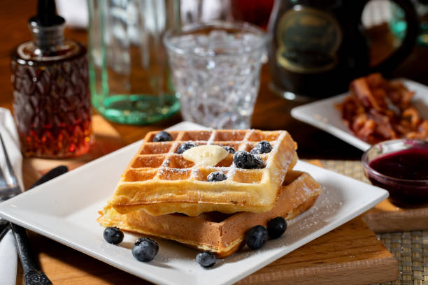 Warm waffles topped with fresh blueberries and melted butter