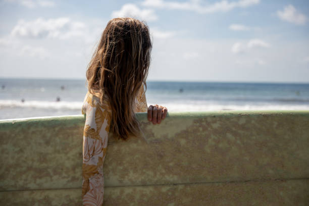 istock Woman Holding Surfboard on Sunny Beach 2194771848