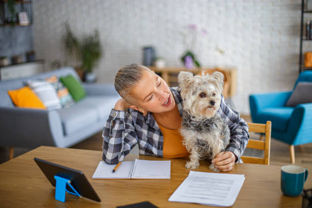 istock Beautiful woman taking a break while working from home with her dog 2194771939