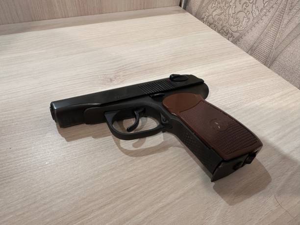 Black gun laying on a wooden table