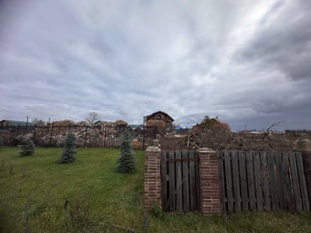 istock Fence surrounds a yard with a brick wall and a small house 2194772006