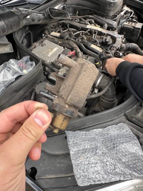 istock Man is working on a car engine, holding a dirty part in his hand 2194772072