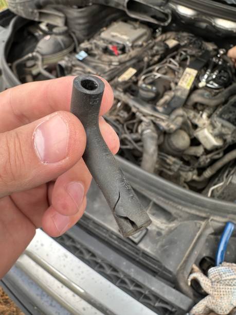 istock Person is holding a black object next to a car engine 2194772084
