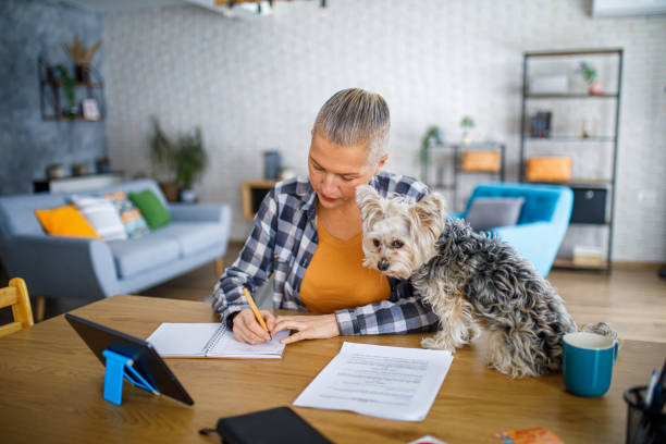 istock Beautiful woman working from home while her dog sits on the desk 2194772292