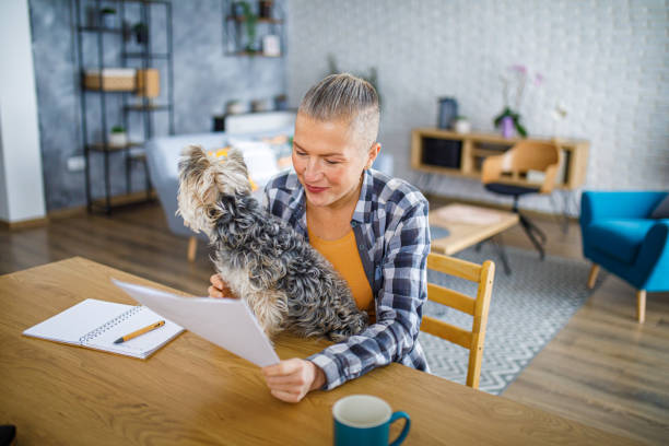 istock Beautiful woman working from home while her dog sits on the desk 2194772352