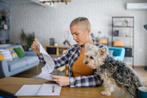 istock Beautiful woman working from home while her dog sits on the desk 2194773034