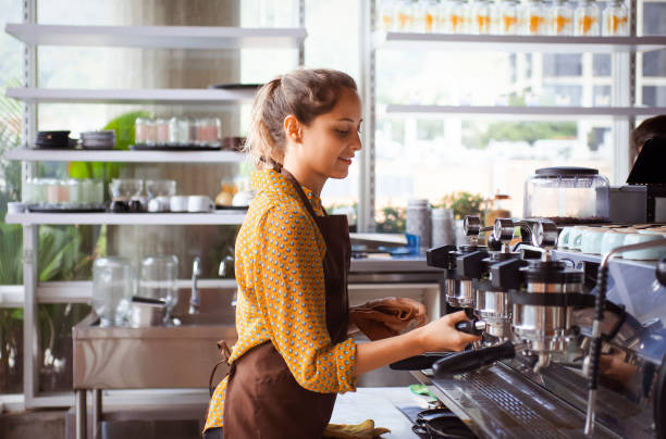 istock Happy young barista preparing coffee with professional machine in cafe 2194773333