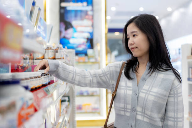 istock Working Woman Choosing Vitamins and Supplements – Exploring Retail Displays in a Pharmacy. Smiling Customer Reflecting Lifestyles of Health, Wellness, and City Life, Balancing Decisions and Relaxation in a Modern Shopping Experience with Confidence and T 2194775226