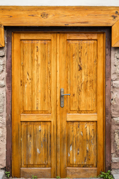 istock Rustic wooden door with metal handle on stone wall background 2194775601