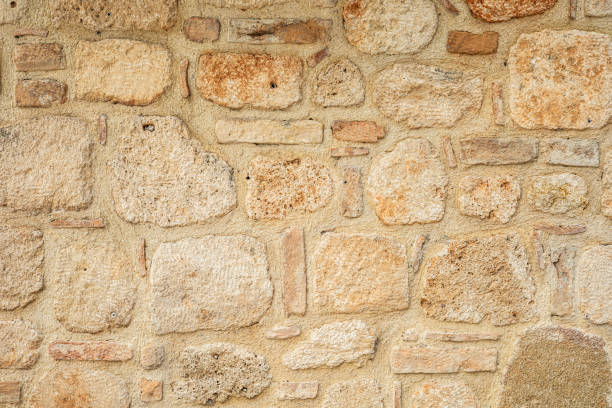istock Rustic textured stone wall with natural beige and brown tones 2194776318