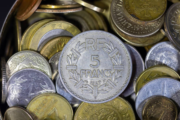 Different gold and silver collector's coins on the wooden table, soft focus background