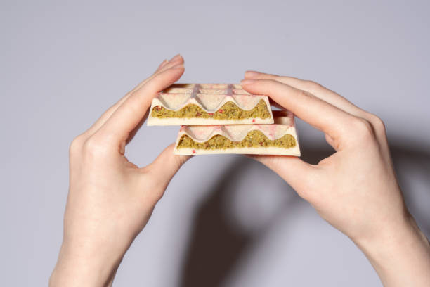 istock Popular white Dubai chocolate with pistachio, dried raspberry, tahini and kadaif, chocolate in woman's hands showing the filling. Confectionery and handmade sweets, chocolatier 2194779840