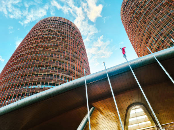 istock Business office building with unique architecture. Modern office building exterior with glass wall and curved steel. view from the ground. 2194782465