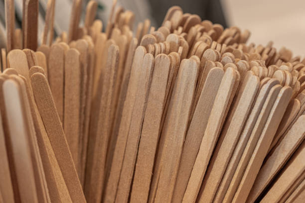 A collection of wooden sticks is neatly stacked one on top of the other in a structured and organized manner