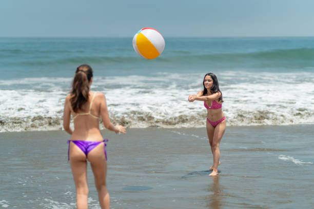istock Two young women playing with inflatable ball on beach 2194785113